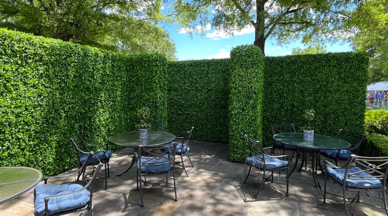 Faux jasmine hedge walls forming a private patio lounge at an outdoor event