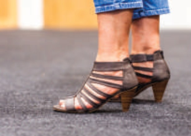 Heeled shoes standing on grey gym floor cover tiles